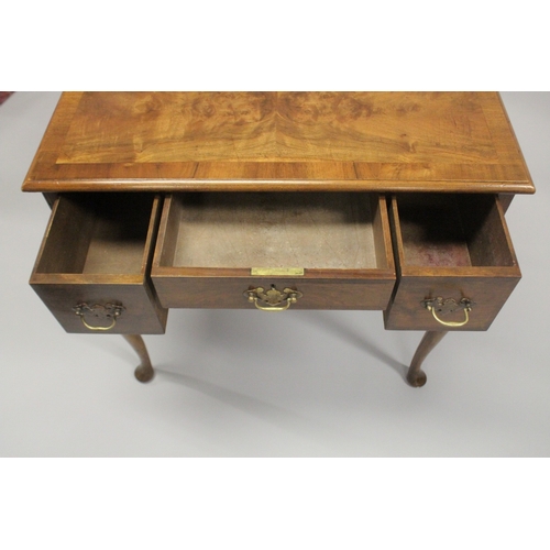 1043 - A GEORGE III DESIGN WALNUT LOW BOY, with a central drawer flanked by a pair of deep drawers on cabri... 