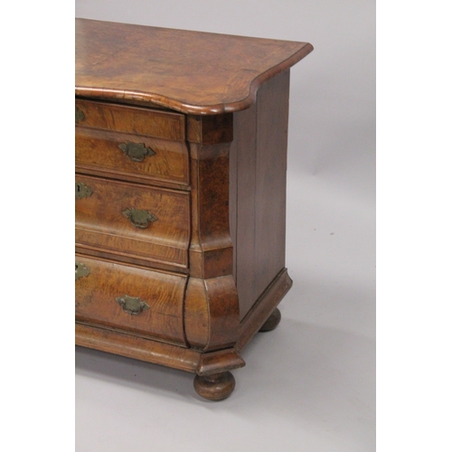 1063 - A GOOD 18TH CENTURY DUTCH WALNUT COMMODE, with crossbanded shaped top, three drawers with brass hand... 