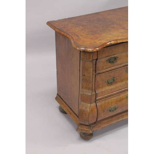 1063 - A GOOD 18TH CENTURY DUTCH WALNUT COMMODE, with crossbanded shaped top, three drawers with brass hand... 