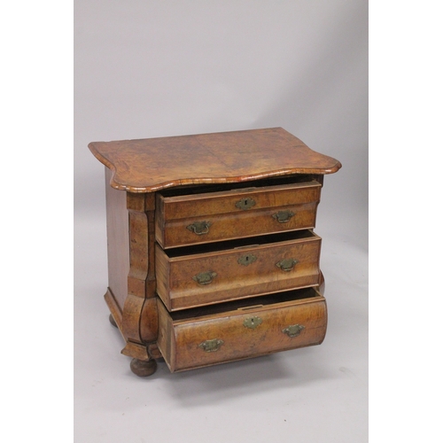 1063 - A GOOD 18TH CENTURY DUTCH WALNUT COMMODE, with crossbanded shaped top, three drawers with brass hand... 