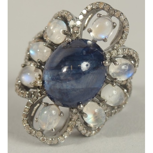 1660 - A LARGE DRESS RING set with a central oval cabochon dark blue sapphire, with surrounding oval caboch... 