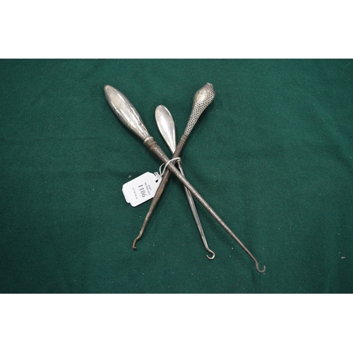 1106 - Three silver handled button hooks.