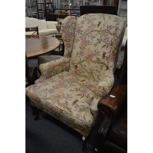 277 - A Georgian style floral upholstered wing armchair.