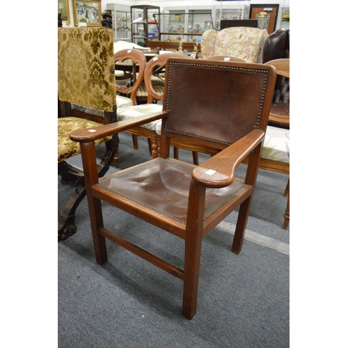 282 - An Arts and Crafts walnut framed armchair with leather upholstered back and seat.