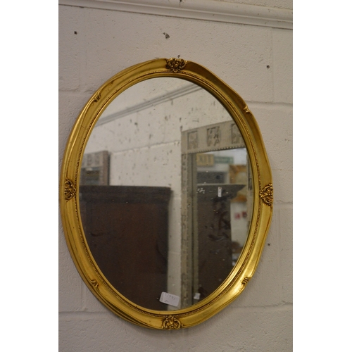 358 - A pair of gilt wood oval mirrors and a similar smaller mirror.