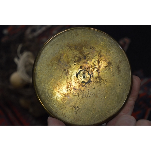 634 - A brass shell case containing a dried floral arrangement.