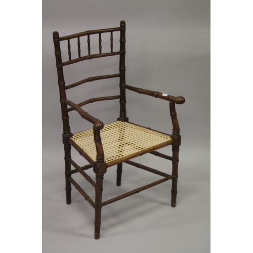 10 - A FAUX BAMBOO COUNTRY ARM CHAIR with canework seat.