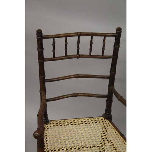 10 - A FAUX BAMBOO COUNTRY ARM CHAIR with canework seat.