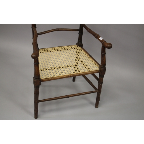 10 - A FAUX BAMBOO COUNTRY ARM CHAIR with canework seat.