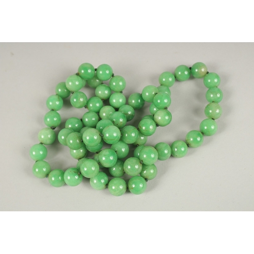 109 - A STRING OF JADE BEADS. 90cms long.