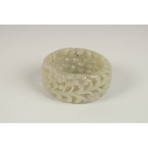 123 - A PIERCED CELADON JADE BANGLE. 7cms diameter.