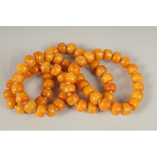 132 - AN AMBER NECKLACE. 72cms high.