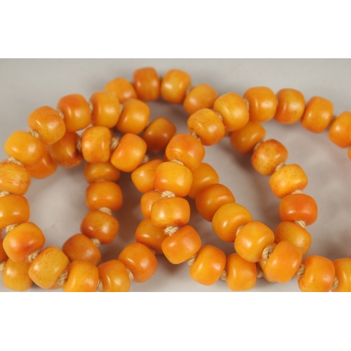 132 - AN AMBER NECKLACE. 72cms high.