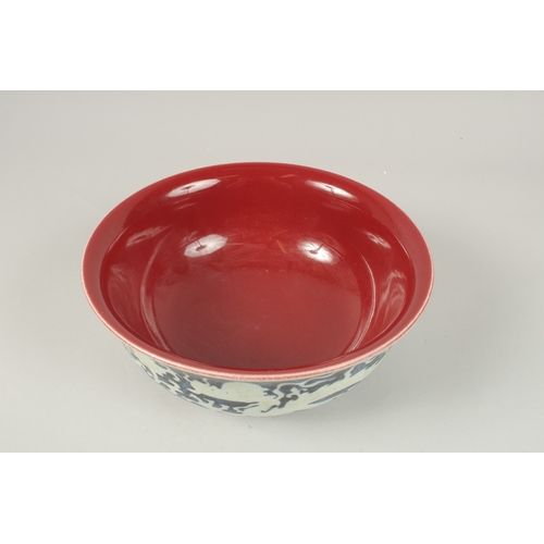 141 - A CHINESE BLUE AND WHITE DRAGON BOWL, with copper red interior. 26.5cms diameter.