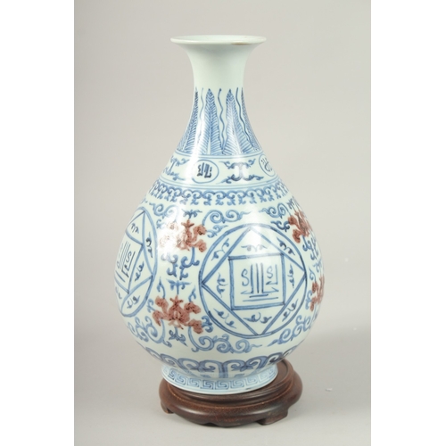 145 - A CHINESE UNDER-GLAZE RED, BLUE AND WHITE VASE with wooden stand. Vase 31cms high.