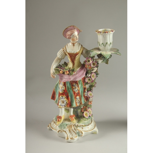 61 - A PAIR OF DERBY FIGURE CANDLESTICKS, as a woman and man, encrusted with flowers, each with a candle ... 