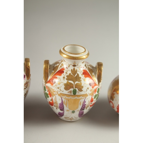 62 - A GARNITURE OF FOUR SMALL PIECES OF CROWN DERBY, scent bottle & stopper and three small vases. Mark ... 