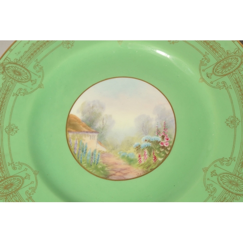 70 - A SET OF FOUR ROYAL WORCESTER CIRCULAR GREEN PLATES the centres painted with a college and flowers, ... 