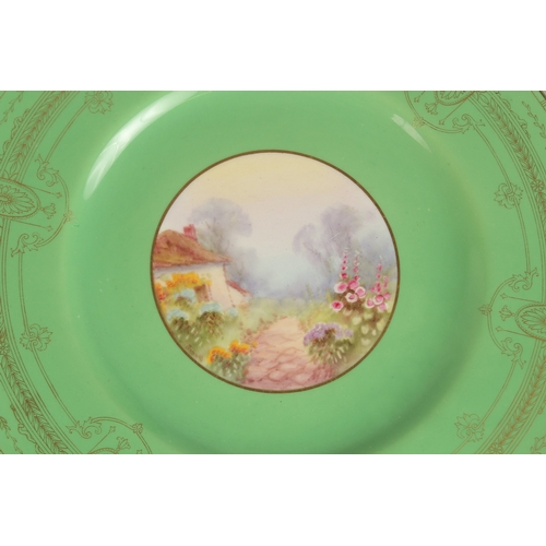 70 - A SET OF FOUR ROYAL WORCESTER CIRCULAR GREEN PLATES the centres painted with a college and flowers, ... 