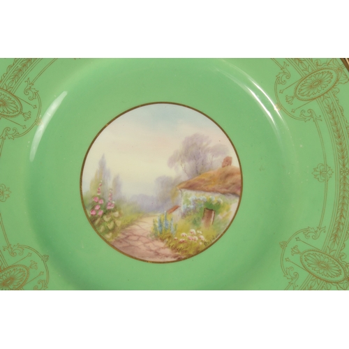 70 - A SET OF FOUR ROYAL WORCESTER CIRCULAR GREEN PLATES the centres painted with a college and flowers, ... 