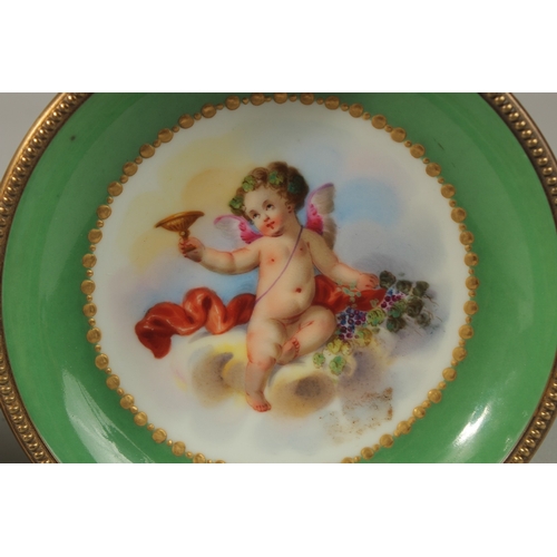 71 - A GOOD PAIR OF SEVRES APPLE GREEN PORCELAIN CIRCULAR TAZZAS painted with cupids, the ormolu bases wi... 