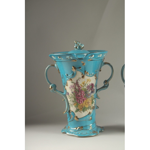 81 - A PAIR OF SEVRES DESIGN BLUE GROUND, TWO HANDLED VASES with reverse panels of flowers. 33cms high.... 