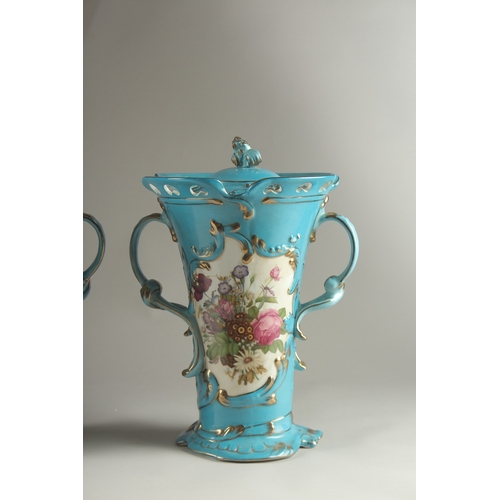 81 - A PAIR OF SEVRES DESIGN BLUE GROUND, TWO HANDLED VASES with reverse panels of flowers. 33cms high.... 