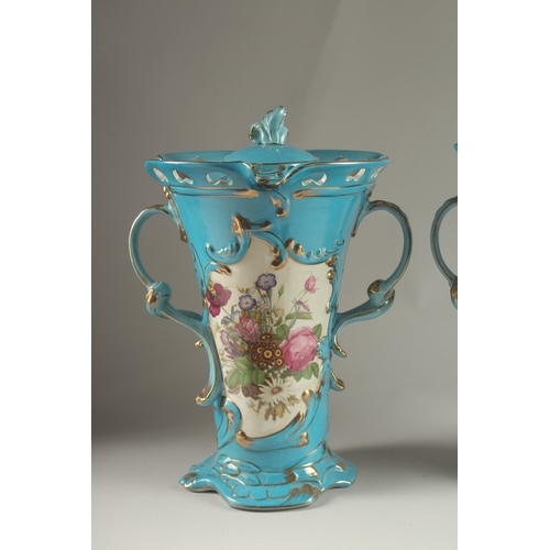 81 - A PAIR OF SEVRES DESIGN BLUE GROUND, TWO HANDLED VASES with reverse panels of flowers. 33cms high.... 