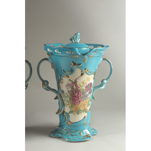 81 - A PAIR OF SEVRES DESIGN BLUE GROUND, TWO HANDLED VASES with reverse panels of flowers. 33cms high.... 