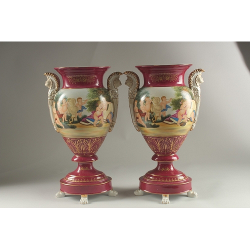 82 - A PAIR OF SEVRES DESIGN RED GROUND TWO HANDLED VASES with classical designs. 40cms high.