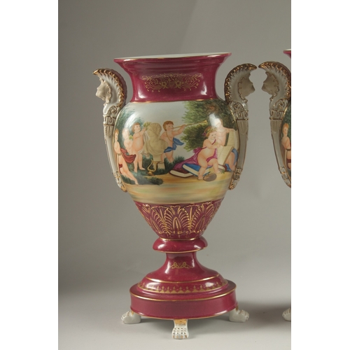 82 - A PAIR OF SEVRES DESIGN RED GROUND TWO HANDLED VASES with classical designs. 40cms high.