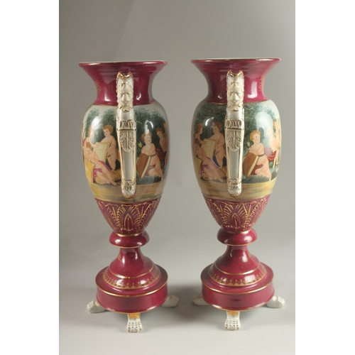 82 - A PAIR OF SEVRES DESIGN RED GROUND TWO HANDLED VASES with classical designs. 40cms high.