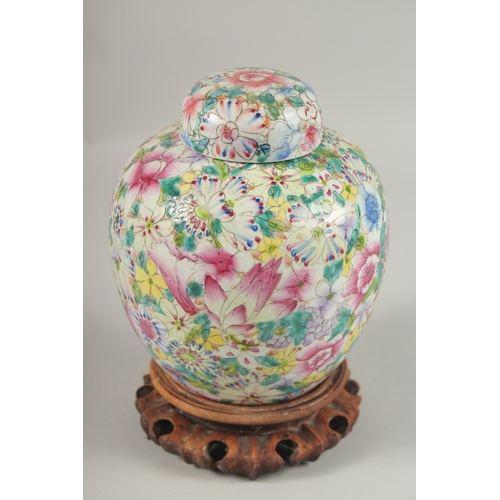 1003 - A CHINESE MILLEFLEURS FAMILLE ROSE PORCELAIN JAR AND COVER, base with character mark, 20cm high.