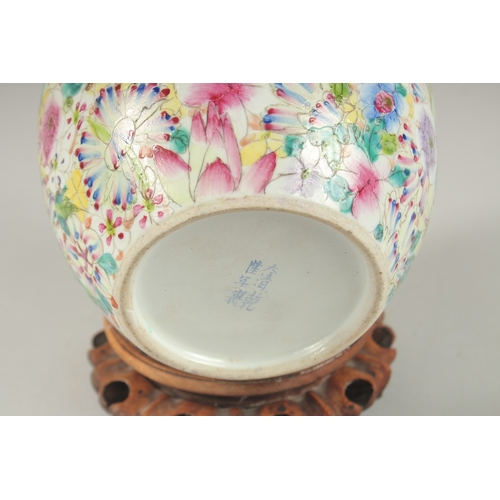 1003 - A CHINESE MILLEFLEURS FAMILLE ROSE PORCELAIN JAR AND COVER, base with character mark, 20cm high.