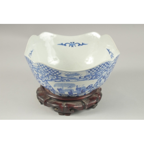 1005 - A CHINESE BLUE AND WHITE PORCELAIN SQUARE FORM BOWL AND HARDWOOD STAND, the bowl with panels of figu... 