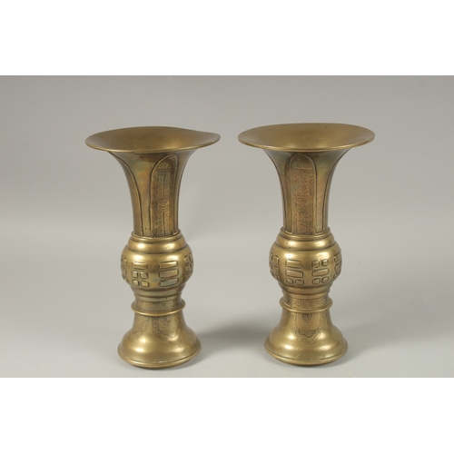 1008 - A PAIR OF CHINESE BRASS TRUMPET FORM VASES, with archaic style designs, the bases with indistinct ma... 