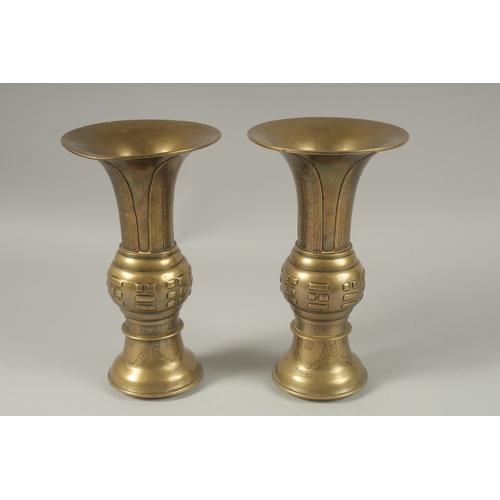 1008 - A PAIR OF CHINESE BRASS TRUMPET FORM VASES, with archaic style designs, the bases with indistinct ma... 