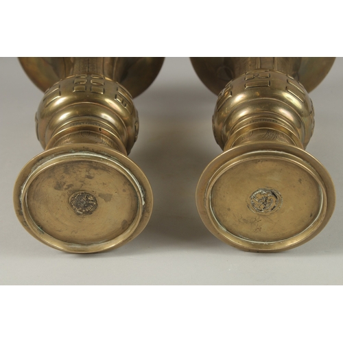 1008 - A PAIR OF CHINESE BRASS TRUMPET FORM VASES, with archaic style designs, the bases with indistinct ma... 