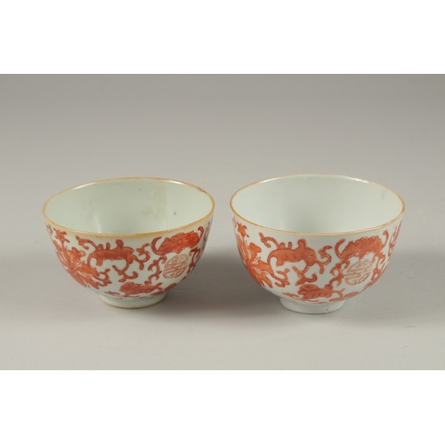 1016 - A PAIR OF CHINESE COPPER RED AND WHITE PORCELAIN BOWLS, with bats and longevity symbols, 10cm diamet... 