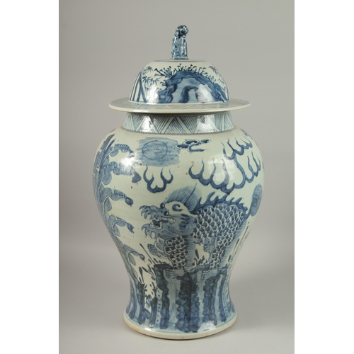 1017 - A LARGE CHINESE BLUE AND WHITE PORCELAIN BALUSTER FORM URN AND COVER, painted with mythical beasts a... 