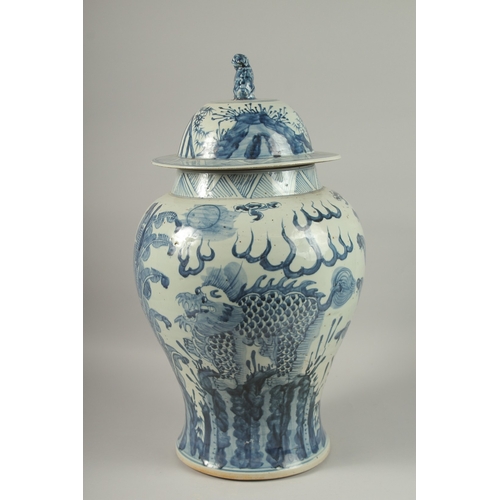 1017 - A LARGE CHINESE BLUE AND WHITE PORCELAIN BALUSTER FORM URN AND COVER, painted with mythical beasts a... 