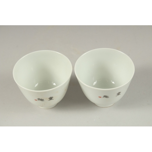 1019 - A PAIR OF CHINESE POLYCHROME PORCELAIN TEA CUPS, painted with boys playing, the base with red charac... 