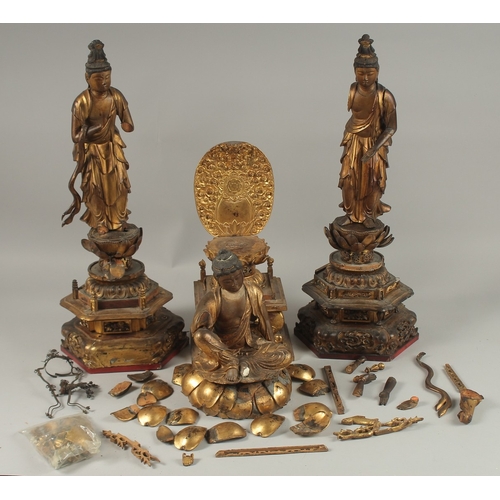 1025 - A COLLECTION OF THREE GILDED CARVED WOOD BUDDHAS AND ACCESSORIES, including stands and various piece... 