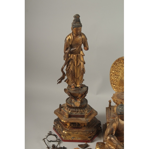 1025 - A COLLECTION OF THREE GILDED CARVED WOOD BUDDHAS AND ACCESSORIES, including stands and various piece... 