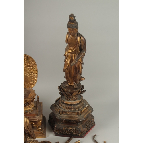 1025 - A COLLECTION OF THREE GILDED CARVED WOOD BUDDHAS AND ACCESSORIES, including stands and various piece... 