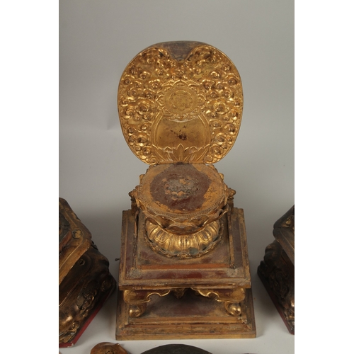 1025 - A COLLECTION OF THREE GILDED CARVED WOOD BUDDHAS AND ACCESSORIES, including stands and various piece... 