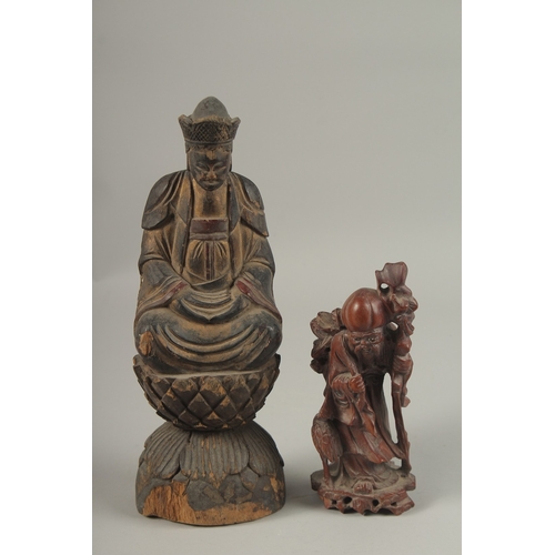 1026 - A CHINESE CARVED WOOD BUDDHA SEATED UPON A LOTUS BASE, with traces of gilt, 31cm high, together with... 