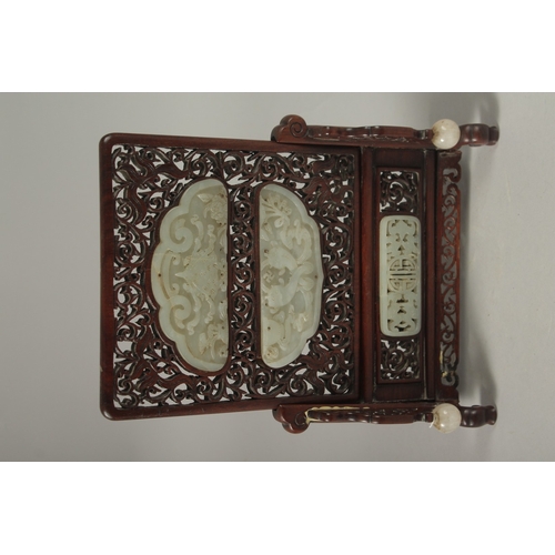 1045 - A PAIR OF SHAPED JADE PLAQUES INSET WITHIN A HARDWOOD FRAME, creating a carved wood table screen, he... 