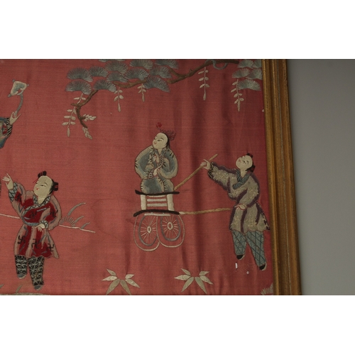 1053 - A LARGE CHINESE EMBROIDERED SILK PANEL, depicting figures, framed and glazed, 33cm x 110cm.