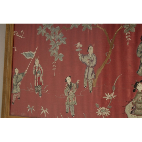 1053 - A LARGE CHINESE EMBROIDERED SILK PANEL, depicting figures, framed and glazed, 33cm x 110cm.